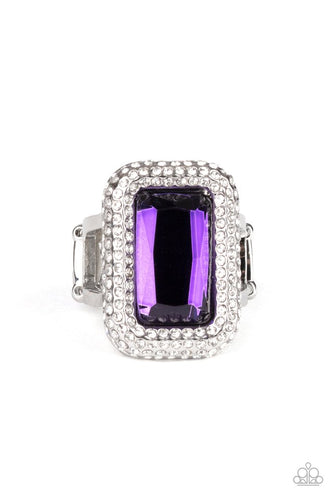 Paparazzi Accessories A Grand STATEMENT-MAKER - Purple Rings featuring a regal emerald style cut, a dramatically oversized purple rhinestone is nestled inside a silver frame encrusted in row after row of glassy white rhinestones for a blinding look. Features a stretchy band for a flexible fit.