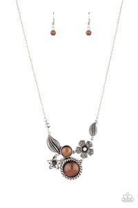 Dotted with brown cat's eye stones and dainty white rhinestones, mismatched floral frames connect below the collar for a whimsical look. Features an adjustable clasp closure.