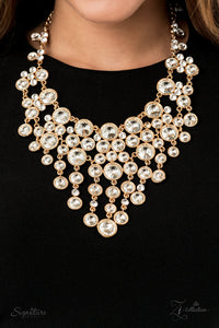 A sparkling storm of classically clustered white rhinestone frames elegantly scatter below the collar. Encased in sleek gold fittings, varied sizes of glassy white rhinestones drip from the bottom of the delicately linked gold frames, resulting in a head-turning twinkle that demands a double take. Features an adjustable clasp closure. 