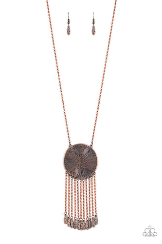 Stamped in a decorative floral pattern, an imperfect copper disc swings from the bottom of a lengthened copper chain. Copper chains and hammered copper beads stream from the bottom of the rustic pendant, creating a flirty fringe. Features an adjustable clasp closure.