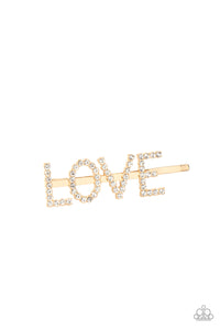 Encrusted in glassy white rhinestones, glistening gold letters spell out the word, "LOVE," across the front of a gold bobby pin for a lovable look.