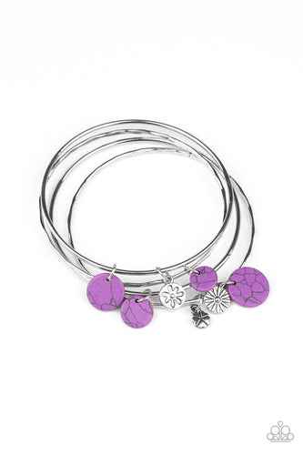 Infused with mismatched silver floral charms and vivacious purple stone discs, a stack of hammered silver bangles slides along the wrist for a colorful earthy look. 