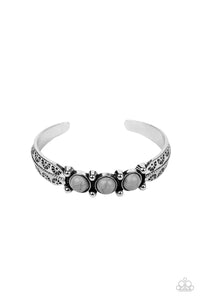 A trio of earthy Sleet stones are encrusted along the center of a dainty silver studded cuff stamped in tribal inspired details for a seasonal flair.