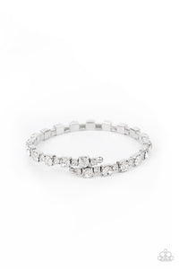 Featuring silver square fittings, dainty and classic white rhinestones delicately alternate along a flexible wire, coiling into a glamorous centerpiece around the wrist.