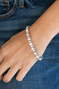 Featuring silver square fittings, dainty and classic white rhinestones delicately alternate along a flexible wire, coiling into a glamorous centerpiece around the wrist.