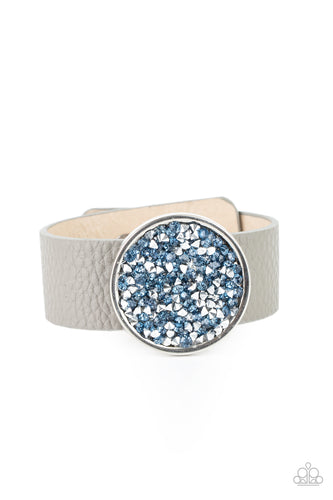 A smoldering display of blue and hematite rhinestones scatter across the front of a silver disc that glides along a gray leather band for a stellar look. Features an adjustable snap closure.