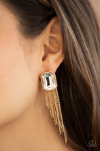 Load image into Gallery viewer, Tapered gold chains stream from the bottom of an oversized white emerald cut gem, creating a regal fringe. Earring attaches to a standard post fitting.
