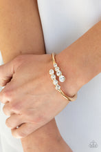 Load image into Gallery viewer, Attached to two substantial gold bars, oversized rows of glittery white rhinestones delicately stack into a hypnotizing centerpiece around the wrist. Features an adjustable hinge closure.
