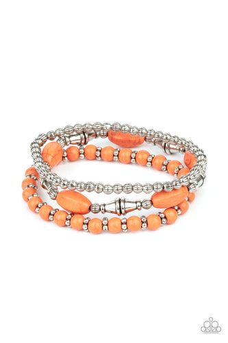 An earthy collection of mismatched orange stones and ornate silver beads are threaded along stretchy bands around the wrist for a colorful artisan flair.
