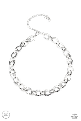 Embossed in a metallic crocodile-like print, asymmetrical silver links delicately connect around the neck for a wild industrial inspired look. Features an adjustable clasp closure. 
