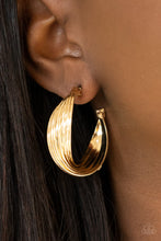 Load image into Gallery viewer, A stack of shiny gold hoops delicately twists at the center, creating a curvaceous display. Earring attaches to a standard post fitting. Hoop measures approximately 1 1/4&quot; in diameter.
