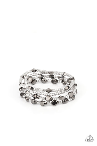 A shimmery collection of dainty silver seed beads and faceted gunmetal accents are threaded along stretchy bands around the wrist, creating glistening layers.