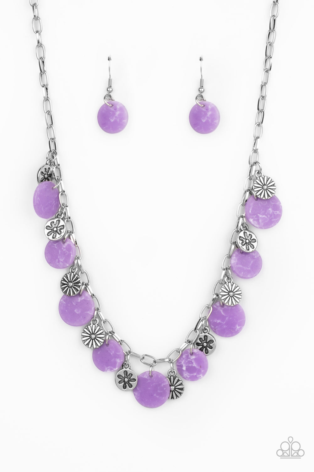 A whimsical collection of mismatched silver floral charms and purple acrylic discs swing from a silver chain, creating a vivacious fringe below the collar. Features an adjustable clasp closure.