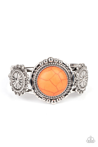 Flanked by two studded silver floral frames, an oversized orange stone adorns the center of a layered silver cuff for an authentic southwestern flair.