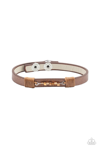 Threaded along a dainty rod, a row of coppery aurum cube beads are knotted in place across the center of a dainty leather band. Features an adjustable snap closure. 