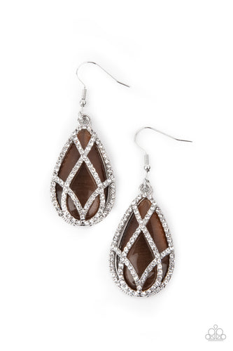 White rhinestone encrusted silver bars crisscross into a glittering beveled teardrop that delicately overlaps an oversized brown teardrop cat's eye stone, creating a luminously layered lure. Earring attaches to a standard fishhook fitting.