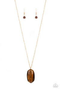 Encased in a classic gold fitting, a glassy Tiger's Eye stone swings from the bottom of a lengthened gold chain for an elegantly earthy look. Features an adjustable clasp closure.