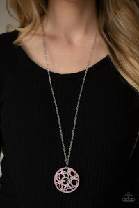 Overlapping silver rings and pink rhinestone encrusted circular frames coalesce into a glittery medallion at the bottom of a lengthened silver chain. Features an adjustable clasp closure.
