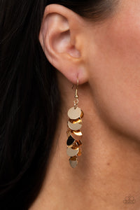 A shimmery collection of dainty gold discs trickle along a dainty gold chain, creating a clustered tassel. Earring attaches to a standard fishhook fitting. 