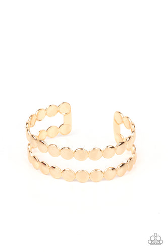 Brushed in a shiny finish, rows of flattened gold studs coalesce into a shimmery cuff around the wrist.