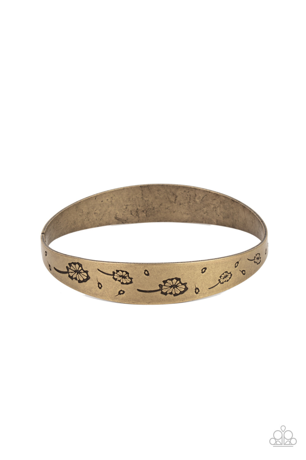 Flowery dandelion-like patterns are stamped across the front of an uneven brass bangle, creating a stackable seasonal display around the wrist.