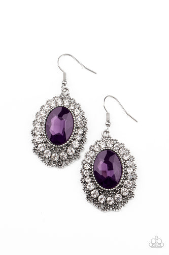 A glittery purple gem is pressed into the center of an ornately studded frame bordered in glassy white rhinestones, creating a glamorous statement piece. Earring attaches to a standard fishhook fitting.