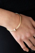 Load image into Gallery viewer, A white rhinestone encrusted fitting glides along a trio of gold bangles, creating a solitaire bracelet around the wrist.
