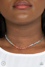 Load image into Gallery viewer, A dainty collection of mismatched silver beads, hematite flecked accents, and orange crystal-like accents are threaded along an invisible wire around the neck for a stellar look. Features an adjustable clasp closure.
