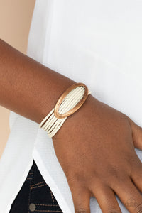 An oval copper fitting glides along strands of rustic white cording, creating colorful layers around the wrist. Features a magnetic closure.