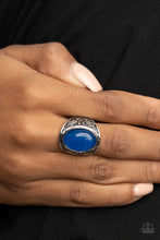Load image into Gallery viewer, An oversized lapis lazuli stone is pressed into the center of a thick silver frame embossed in antiqued tribal inspired patterns, creating an enchanting centerpiece atop the finger. Features a stretchy band for a flexible fit. 
