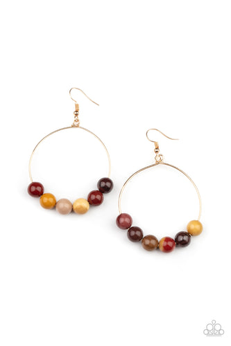 An oversized collection of earthy stones slide along the bottom of a dainty gold hoop, creating an earthy centerpiece. Earring attaches to a standard fishhook fitting.