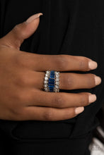 Load image into Gallery viewer, Flanked between two sparkly rows of stunning white rhinestones, a row of glittery blue emerald cut rhinestones gradually increase in size at the center for a dramatically stacked look across the finger. Features a stretchy band for a flexible fit.
