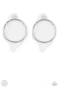A warped piece of clear acrylic attaches to a double-sided post, while an oversized silver hoop peeks out beneath the ear for a bold look. Earring attaches to a standard post fitting