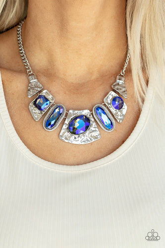 Mismatched French Blue gems adorn the front of hammered silver plates that abstractly connect below the collar, creating an out-of-this-world statement piece. Features an adjustable clasp closure.  Sold as one individual necklace. Includes one pair of matching earrings.