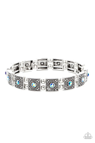 Dotted with iridescent blue rhinestone centers, studded silver frames alternate with pairs of dainty silver beads along stretchy bands, creating a stellar centerpiece around the wrist.