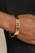 Load image into Gallery viewer, The center of a shiny gold cuff is stamped in the word, &quot;Hope,&quot; for an inspirational look.
