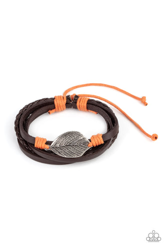 A lifelike silver leaf frame is knotted in place with orange cording across the front of a dainty brown leather band. Matching plain and braided leather bands join the centerpiece, creating earthy layers around the wrist. Features an adjustable sliding knot closure.