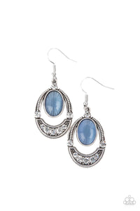 A glowing blue cat's eye stone attaches to the top of a studded silver frame. The bottom of the oval is encrusted in glassy white rhinestones, creating a whimsical display. Earring attaches to a standard fishhook fitting.