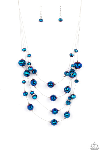 Featuring an oil spill finish, metallic blue beads and faceted crystal-like accents are fitted in place along dainty wires, creating the illusion of floating layers below the collar. Dainty silver beads and white rhinestone encrusted silver rings sporadically embellish the stellar display for a timeless finish. Features an adjustable clasp closure