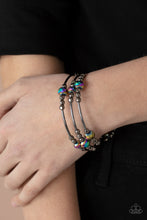 Load image into Gallery viewer, A shimmery collection of dainty gunmetal beads, oil spill crystal-like accents, and gunmetal rods are threaded along a coiled wire around the wrist, creating a stellar infinity wrap bracelet.
