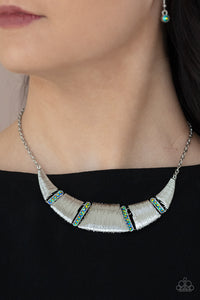 Embossed in linear textures, trapezoidal and triangular silver plates delicately link with dainty iridescent metallic rhinestone encrusted frames, creating a dramatic half moon below the collar. Features an adjustable clasp closure. 