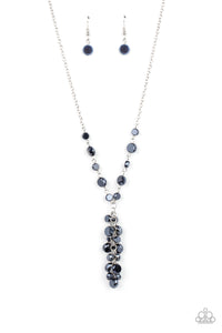 A faceted collection of metallic blue crystal-like beads delicately links below the collar. A tassel of matching beads cascades from the center, creating a stellar extended pendant. Features an adjustable clasp closure.