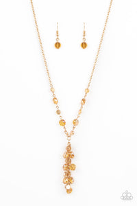 Dipped in a rainbow iridescence, a faceted collection of golden crystal-like beads delicately links below the collar. A tassel of matching beads cascades from the center, creating a stellar extended pendant. Features an adjustable clasp closure.