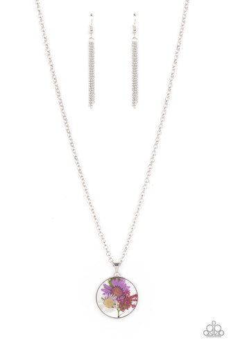 A leafy collection of colorful wildflowers is encased inside a glassy frame, creating a whimsical pendant at the bottom of the lengthened silver chain. Features an adjustable clasp closure.
