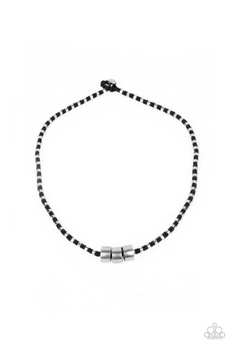 Three bold silver accents slide along a knotted black cord adorned in dainty silver rings, creating an edgy display below the collar. Features a button loop closure. 