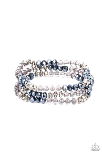 Infused with faceted silver beads, a glamorous collection of metallic blue crystals and smoky beads are threaded along stretchy bands around the wrist, creating glittery layers. 