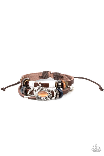 Infused with a scalloped orange cat's eye stone centerpiece, three layered leather bands are embellished with a mismatched collection of wooden and metallic rings for a seasonal finish. Features an adjustable sliding knot closure.