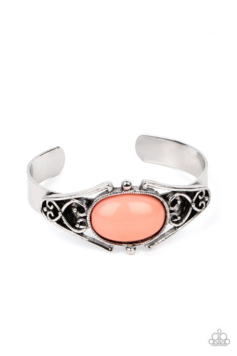 A bubbly Burnt Coral bead is nestled inside a silver filigree filled frame atop a dainty silver cuff, creating a whimsical centerpiece around the wrist.