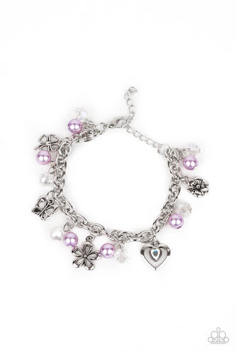 Infused with purple pearls and iridescent crystal-like beads, mismatched silver charms including a clover, butterfly, heart, and floral frames swing from a chunky silver chain around the wrist. Features an adjustable clasp closure.