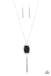 Encased in an antiqued silver frame, an oversized black gem swings from the bottom of an ornate silver chain. A shimmery silver chain tassel swings from the bottom of the sparkly pendant, creating a regal talisman. Features an adjustable clasp closure. 